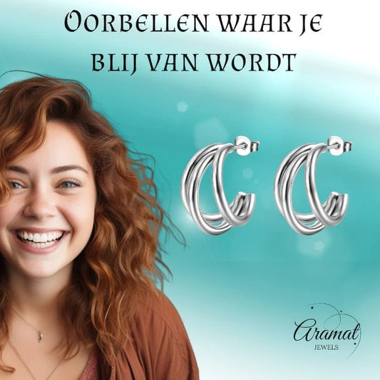 Lachende vrouw met Aramat Jewels zilverkleurige triple halve oorringen van roestvrij staal, 25mm hoepel oorstekers.