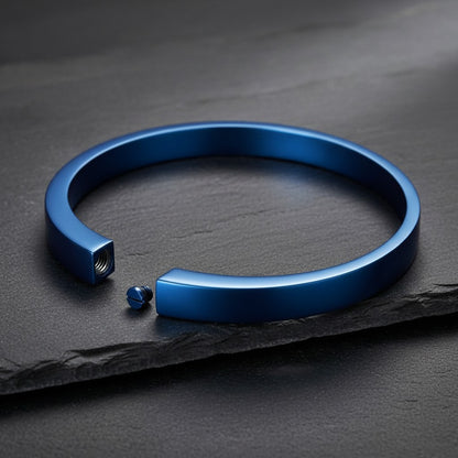 Aramat Jewels blauwe stalen asarmband van 60mm met schroefsluiting voor crematie-as op een donkere ondergrond.