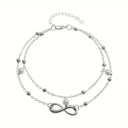 Aramat Jewels dubbel enkelbandje in zilverkleur met infinity symbool en witte parels voor een zomerse look.