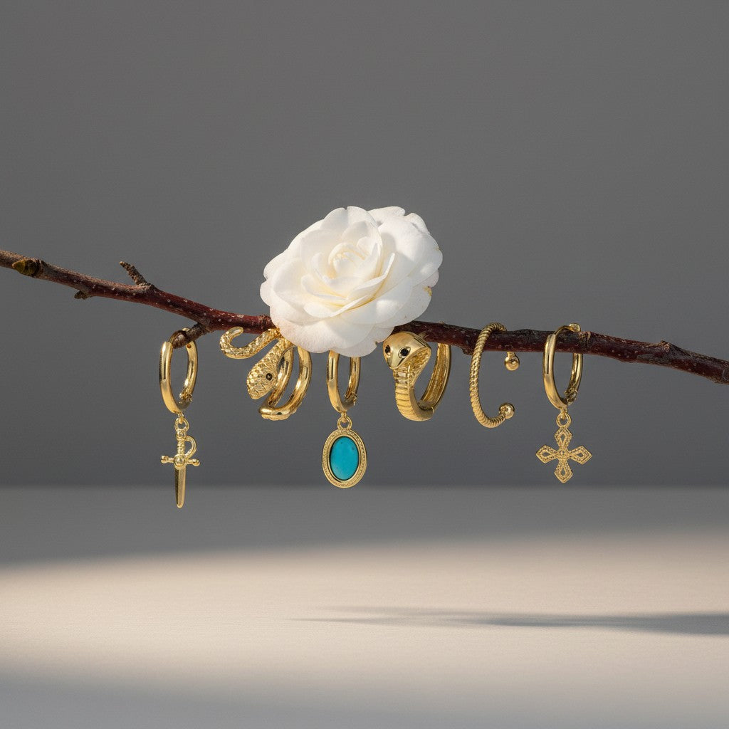 Aramat Jewels gold-plated 925 silver earring set with charms: sword, turquoise oval, snake, twisted hoop, and cross.