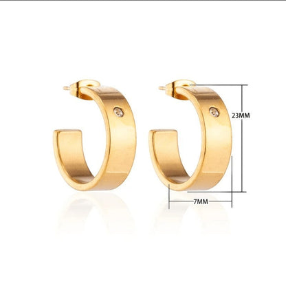 Aramat Jewels gold-tone stainless steel hoop earrings with a small clear cubic zirconia accent, 23mm diameter.