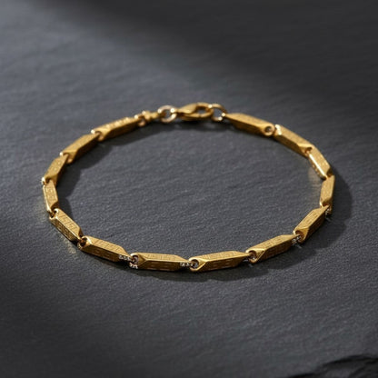 Goudkleurige Aramat Jewels schakelarmband van 316L roestvrij staal met een verfijnd Grieks motief op de staafjes.