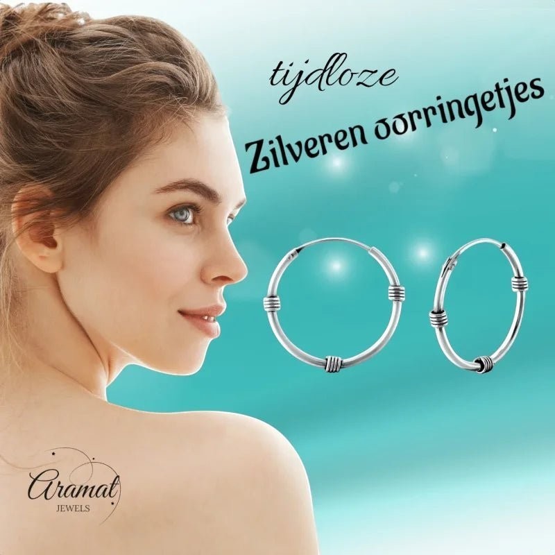Aramat Jewels oxidised silver Bali hoop earrings, 20mm diameter, with a rustic, vintage design. A woman's profile is visible on the left.