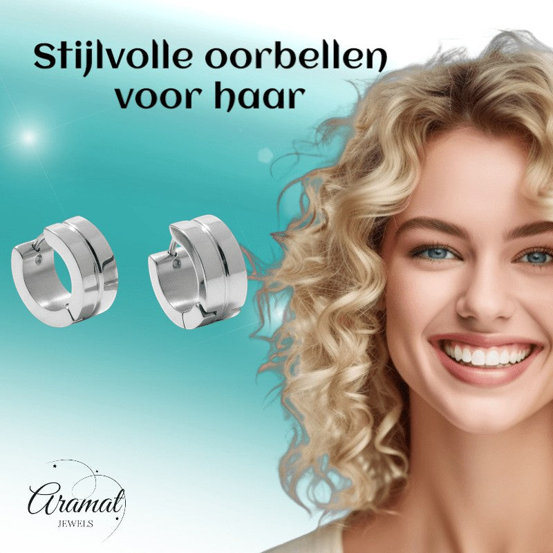Aramat Jewels silver-tone stainless steel huggie hoop earrings with a subtle striped accent. Model has blonde curly hair and blue eyes.