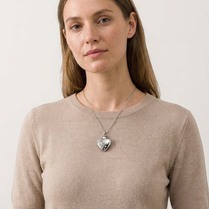 Aramat Jewels® zilverkleurige stalen ashanger in hartvorm met zirkonia pootjes, gedragen door een model.