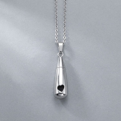 Aramat Jewels zilverkleurige RVS druppelvormige ashanger met opengewerkt hartje, 3,1cm lang, met schroefsluiting.