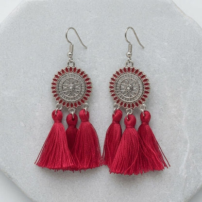 Aramat Jewels zomerse boho oorhangers met rode kwastjes en zilverkleurig metaal.