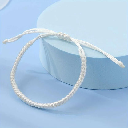 Een witte touwarmband met een knoop erop