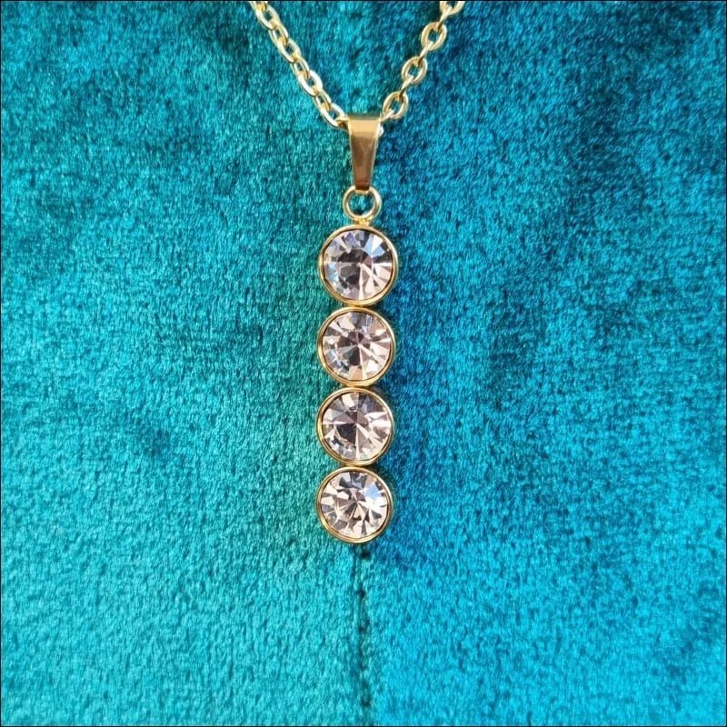 Een gouden halsketting met drie stenen eraan