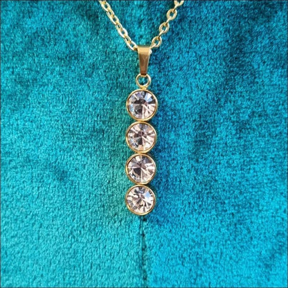 Een gouden halsketting met drie stenen eraan