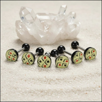 Aramat Jewels surgical steel tongue piercing with black acrylic balls and a cream-colored logo featuring playing card suits.
