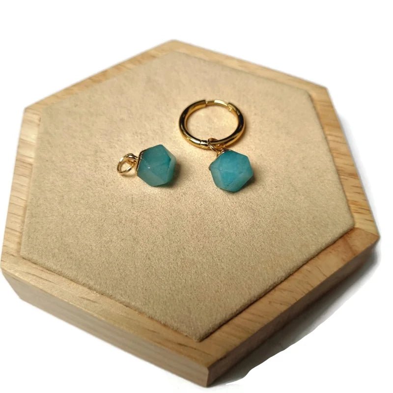 Een paar turquoise blauwe glazen oorbellen op een houten doosje