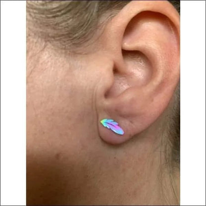 Een vrouw met een regenboogkleurige oorpiercing