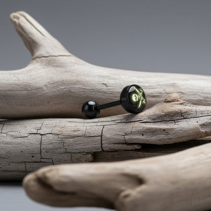 Aramat Jewels black bioplast tongue piercing with a glow-in-the-dark skull and crossbones logo.