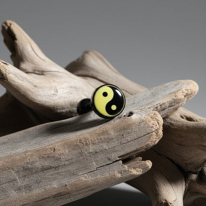 Aramat Jewels black bioplast tongue piercing with a yellow and black yin yang symbol design.